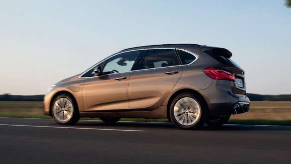 Imagine cu trei sferturi din partea laterală a unui BMW 225xe Active Tourer F45 plug-in hybrid care se deplasează Imagine cu trei sferturi din partea laterală a unui BMW 225xe Active Tourer F45 plug-in hybrid care se deplasează pe stradă