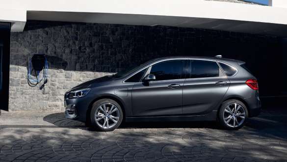 Imagine din partea laterală a unui BMW 225xe Active Tourer F45 plug-in hybrid Imagine cu trei sferturi din partea laterală a unui BMW 225xe Active Tourer F45 plug-in hybrid în faţa unei clădiri