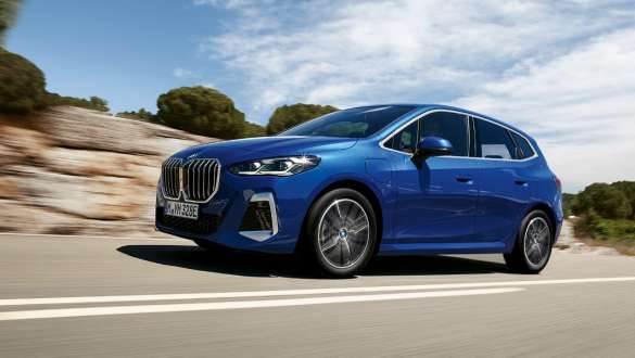 BMW Seria 2 Active Tourer 230e plug-in hybrid deplasându-se pe un drum rural Imagine din partea laterală a BMW Seria 2 Active Tourer 230e plug-in hybrid, în Albastru Portimao M, în timp ce se deplasează pe un drum rural