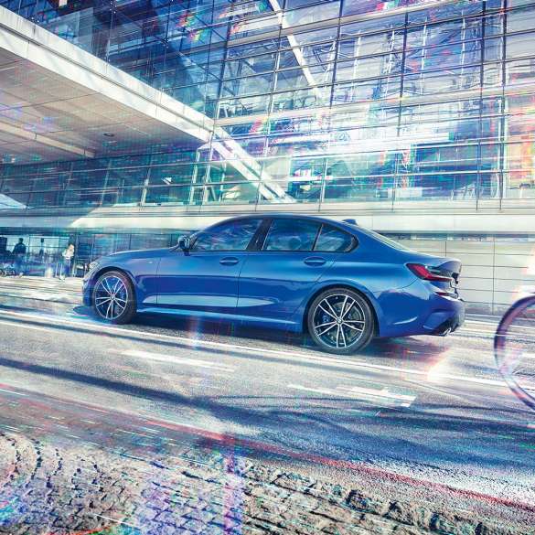 Perspectivă din lateral a BMW Seria 3 Sedan. Perspectivă din lateral a BMW Seria 3 Sedan staţionând pe timp de zi, în faţa unei clădiri din sticlă.