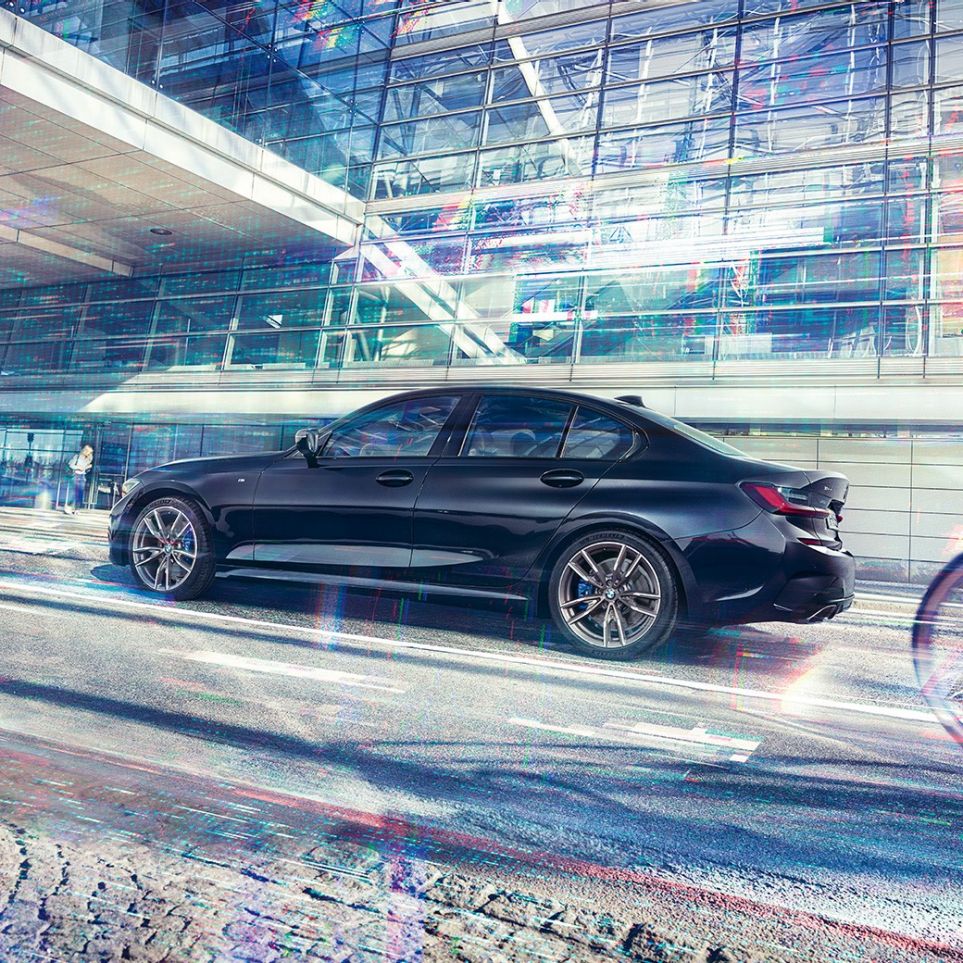 BMW M340i xDrive al BMW Seria 3 Sedan. Perspectivă laterală a BMW M340i xDrive în faţa unei clădiri dintr-o zonă urbană.