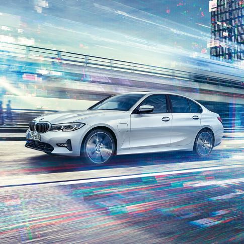 Perspectivă laterală a BMW Seria 3 Sedan 330e rulând. Perspectivă laterală a BMW Seria 3 Sedan 330e rulând în faţa unui peisaj urban.