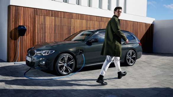 Imagine cu trei sferturi din partea laterală a unui BMW Seria 3 Touring plug-in hybrid 2021 G21 conectat la BMW Wallbox Imagine cu trei sferturi din partea laterală a unui BMW Seria 3 Touring plug-in hybrid 2021 G21 conectat la BMW Wallbox