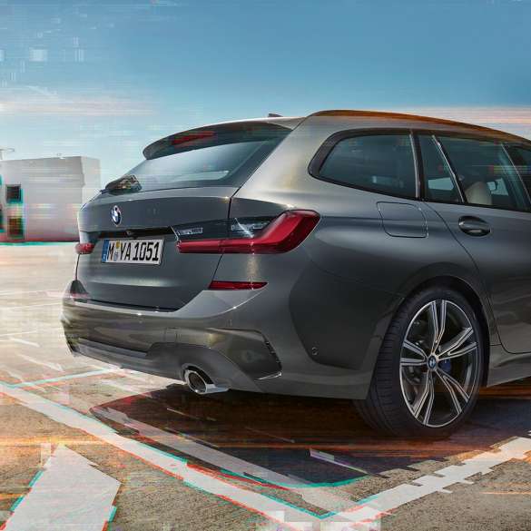 Imagine cu trei sferturi din partea spate a BMW Seria 3 Touring, într-o parcare Imagine cu trei sferturi din partea spate a BMW Seria 3 Touring, într-o parcare dintr-un mediu urban