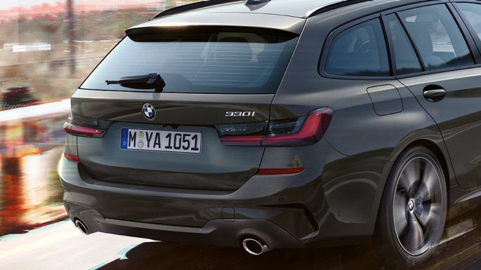 Imagine cu trei sferturi din partea spate a BMW Seria 3 Touring Imagine cu trei sferturi din partea spate a BMW Seria 3 Touring, rulând pe un pod, într-un mediu rural