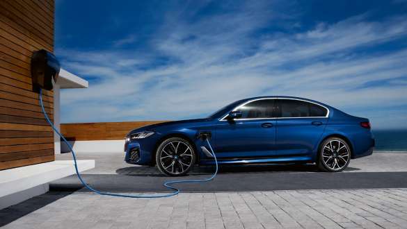 Imagine din partea laterală a unui BMW Seria 5 Sedan plug-in hybrid Imagine din partea laterală a unui BMW Seria 5 Sedan plug-in hybrid conectat la BMW Wallbox