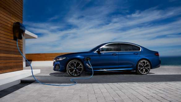 Imagine din partea laterală a unui BMW Seria 5 Sedan plug-in hybrid Imagine din partea laterală a unui BMW Seria 5 Sedan plug-in hybrid conectat la BMW Wallbox