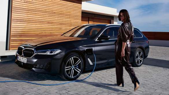Imagine cu trei sferturi din partea laterală a unui BMW Seria 5 Touring G31 LCI 2021 plug-in hybrid, la încărcat Imagine cu trei sferturi din partea laterală a unui BMW Seria 5 Touring G31 LCI 2021 plug-in hybrid, la încărcat cu un model