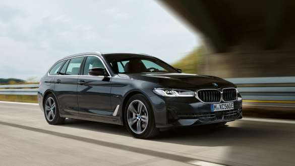 Imagine cu trei sferturi din partea frontală a unui BMW Seria 5 Touring G31 LCI 2021 plug-in hybrid, rulând Imagine cu trei sferturi din partea frontală a unui BMW Seria 5 Touring G31 LCI 2021 plug-in hybrid, rulând pe stradă