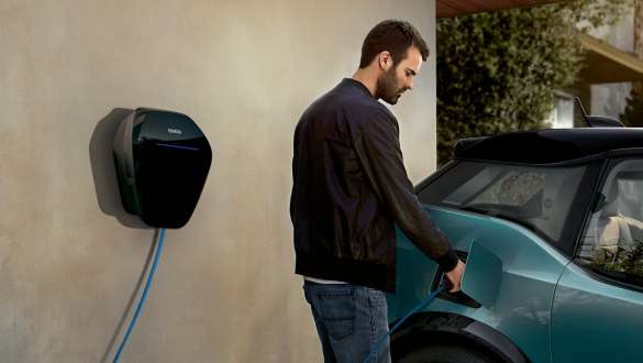 Bărbat încărcând automobilul său BMW i3 I01 2018 la BMW Wallbox Bărbat cu un cablu de încărcare BMW Wallbox BMW i3 I01 2018 Albastru Ridge Mountain cu detalii în Gri Frozen
