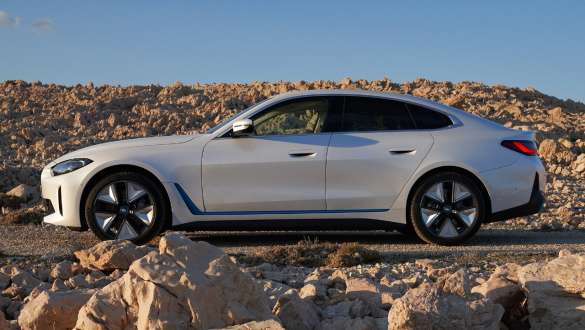 Imagine din partea laterală a unui BMW i4 eDrive40 G26 2021 care se află pe un drum neamenajat Imagine din partea laterală a unui BMW i4 eDrive40 G26 2021 Alb Mineral care se află pe un drum neamenajat
