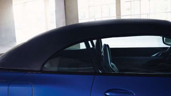 Softtop-ul BMW M4 Competition Cabriolet G83 2021 cu xDrive M Imagine cu softtop-ul închis şi bărbat în faţă a BMW M4 Competition Cabriolet G83 2021 cu xDrive M, în BMW Individual Albastru Frozen Portimao