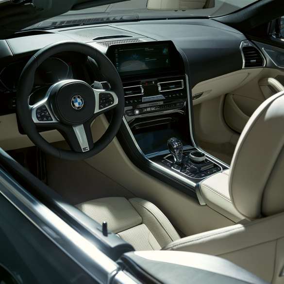 Habitaclul BMW M850i xDrive Cabriolet. BMW M850i xDrive Cabriolet în Gri Dravit metalizat cu soft-top-ul deschis şi habitaclul cu volan M îmbrăcat în piele.