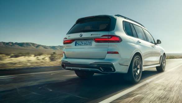 BMW X7 M G07 2019 cu sistem de control al suspensiei Executive Drive Pro Imagine cu trei sferturi din partea din spate a unui BMW X7 M G07 2019 cu sistem de control al suspensiei Executive Drive Pro în timp ce se deplasează