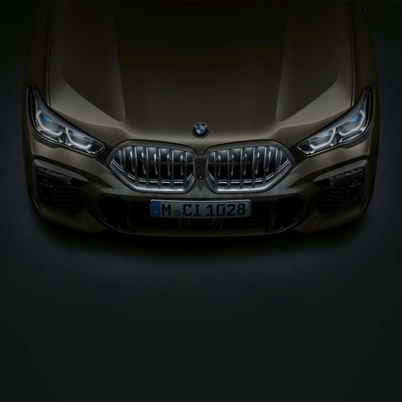 Partea frontală a BMW X6. Perspectivă de sus a BMW X6 cu grila frontală „Iconic Glow” în prim-plan.
