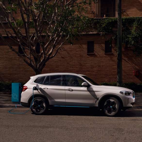 Imagine din lateral cu BMW iX3, G08, la o staţie publică cu putere mare de încărcare Imagine din lateral cu BMW iX3, G08, 2020, în Alb Mineral metalizat, la o staţie publică cu putere mare de încărcare