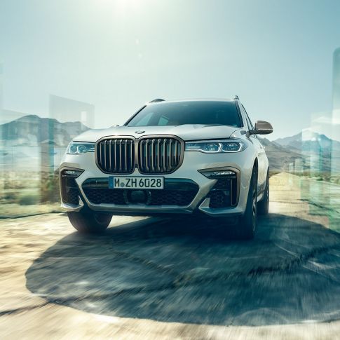 Imagine cu perspectivă de jos asupra BMW X7 M50d BMW X7 M50d: imagine înclinată cu perspectivă de jos asupra BMW X7 alb, rulând
