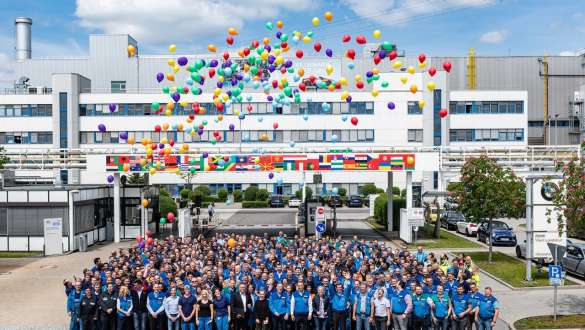 Social Vânzări speciale BMW Hub de sustenabilitate Prezentare generală Vânzări speciale BMW Hub de sustenabilitate Prezentare generală Social Angajaţi BMW în faţa clădirii cu baloane colorate în aer