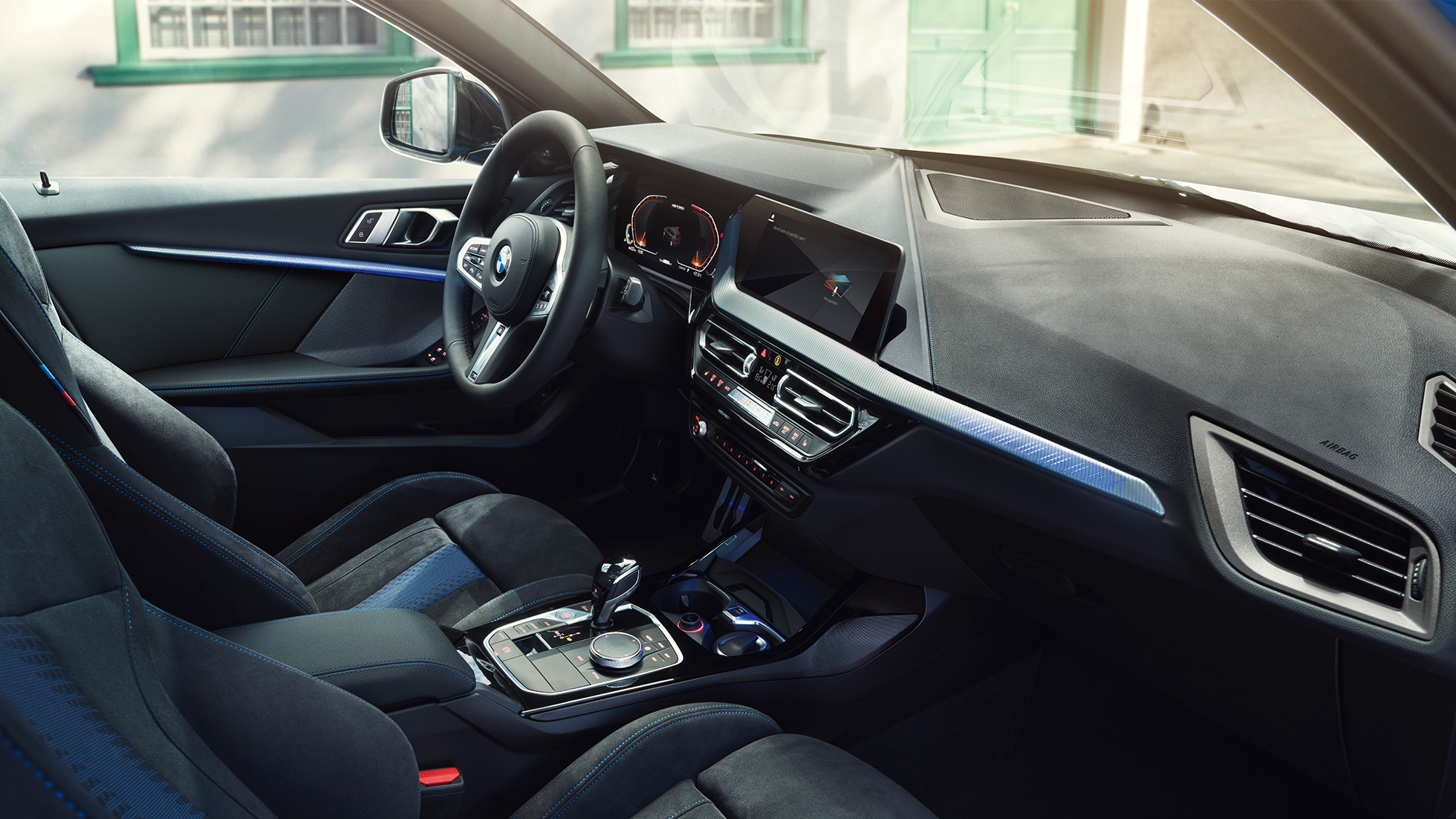 Imagine cu interiorul sportiv al BMW Seria 1. Imagine cu habitaclul BMW Seria 1 cu scaune M Sport, volan M îmbrăcat în piele şi ornamente interioare iluminate.