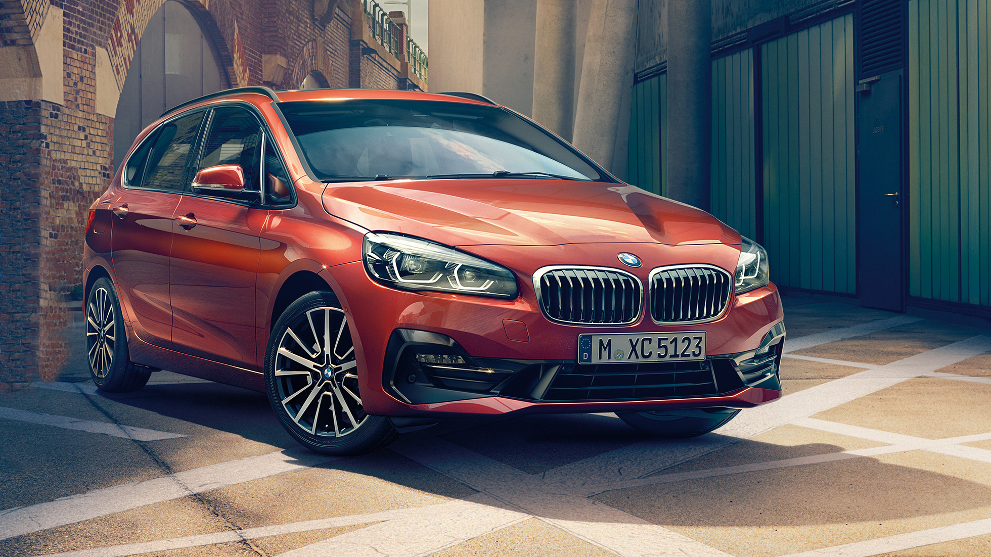 Exteriorul BMW Seria 2 Active Tourer Imagine cu trei sferturi din partea frontală a BMW Seria 2 Active Tourer, F45, 2018, în Orange Sunset metalizat, parcat pe o alee