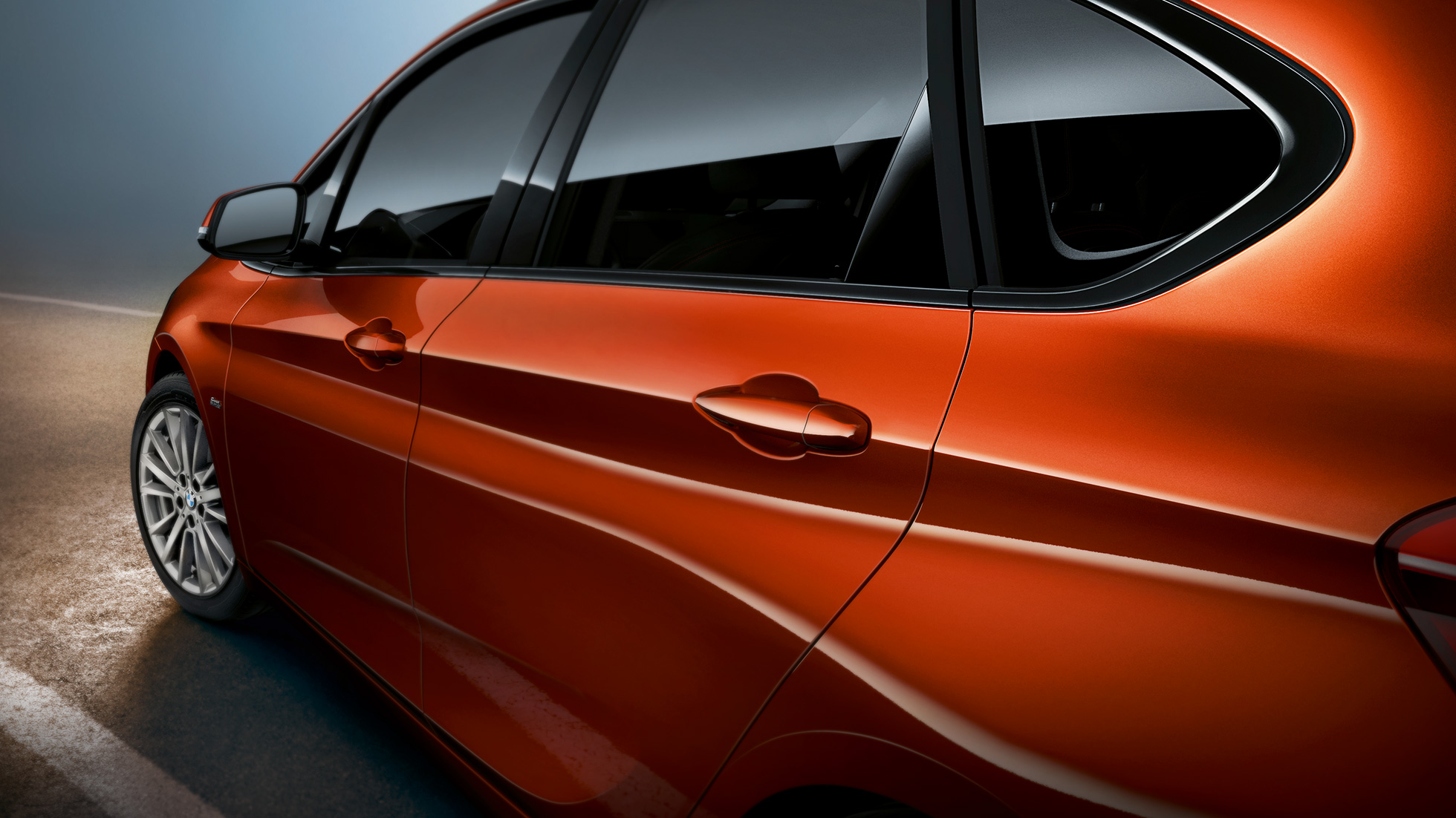 Imagine în prim-plan cu partea laterală a BMW Seria 2 Active Tourer Imagine în prim-plan cu partea laterală a BMW Seria 2 Active Tourer, F45, în Portocaliu Sunset metalizat