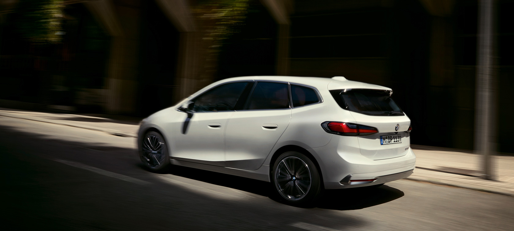 Imagine din partea spate a BMW Seria 2 Active Tourer, în mişcare Imagine din partea spate a BMW Seria 2 Active Tourer, în Alb Mineral, în mişcare