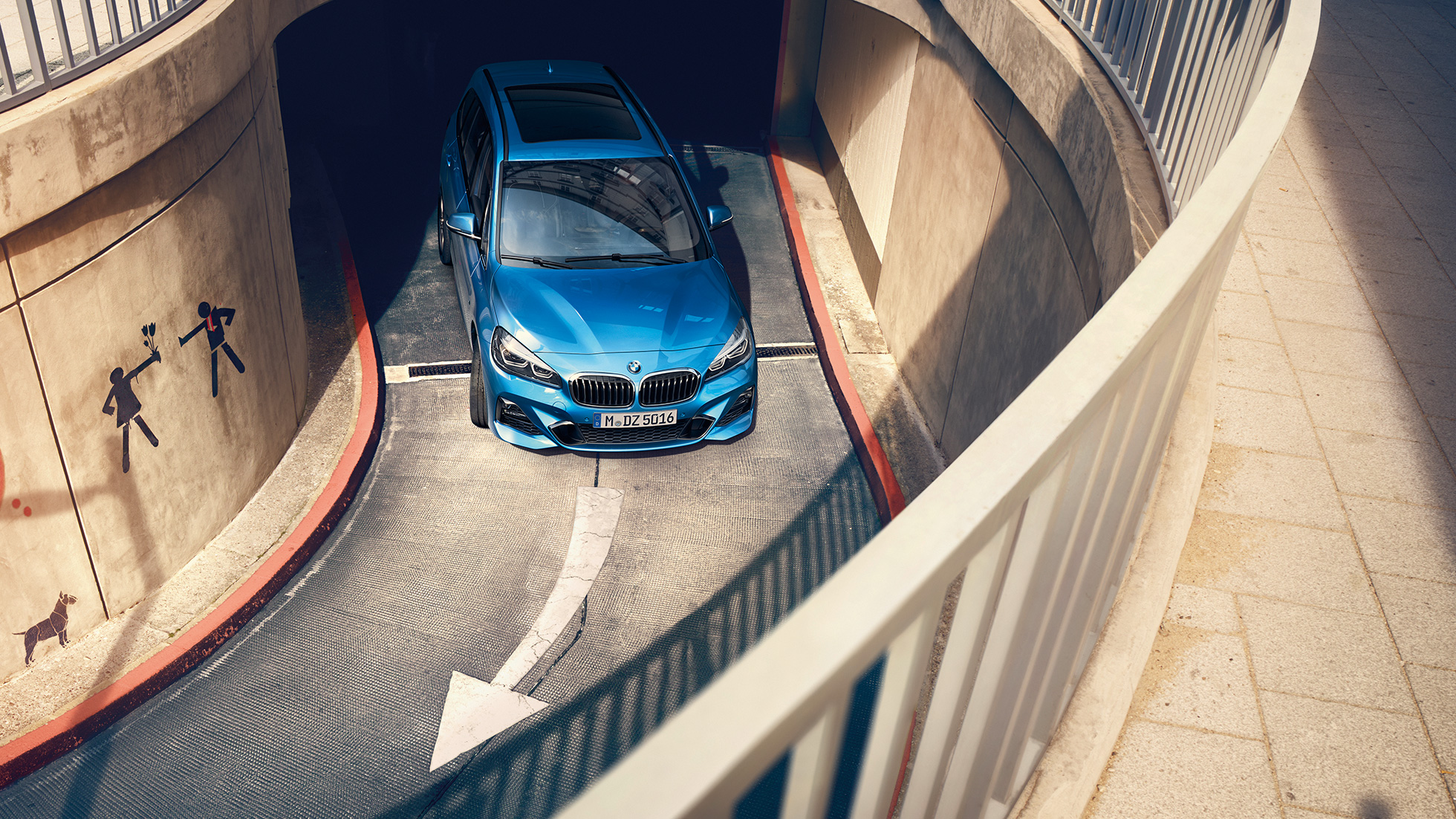 BMW Seria 2 Gran Tourer rulând într-o parcare supraetajată Imagine din unghi înalt cu un BMW Seria 2 Gran Tourer, F46 Facelift 2018, în Albastru Misano metalizat, într-o parcare cu etaj