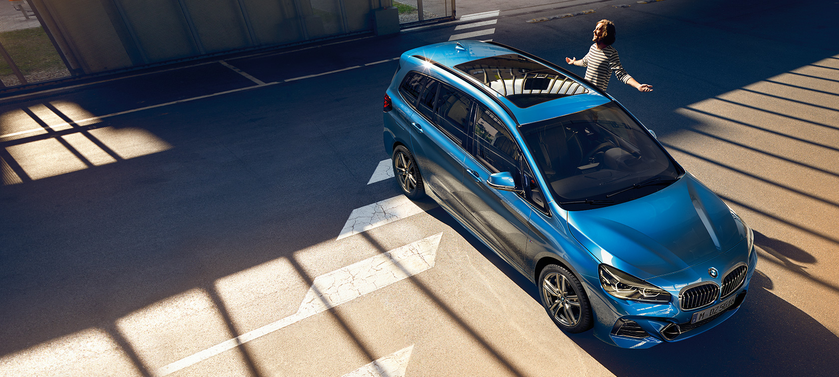 Imagine cu o familie stand lângă un BMW Seria 2 Gran Tourer, F46 Facelift 2018, în Albastru Misano metalizat