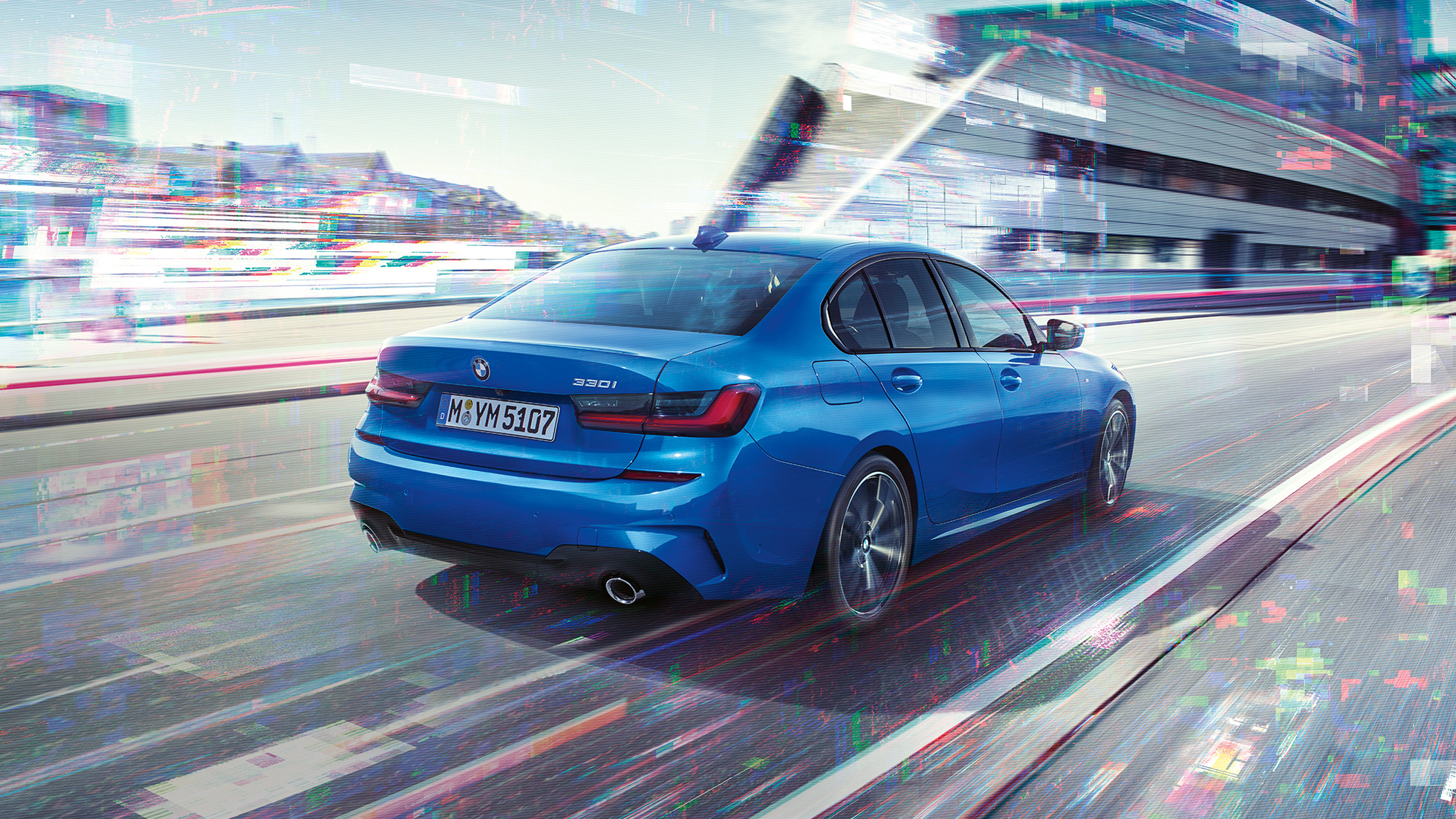 Imagine cu partea laterală spate a BMW Seria 3 Sedan Imagine cu trei sferturi din partea spate a BMW Seria 3 Sedan, rulând pe timpul zilei, în faţa unui peisaj urban