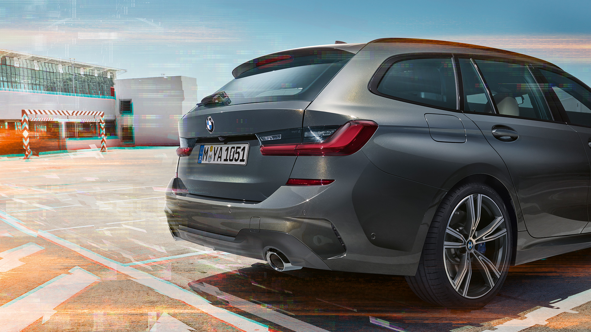 Imagine cu trei sferturi din partea spate a BMW Seria 3 Touring, într-o parcare Imagine cu trei sferturi din partea spate a BMW Seria 3 Touring, într-o parcare dintr-un mediu urban