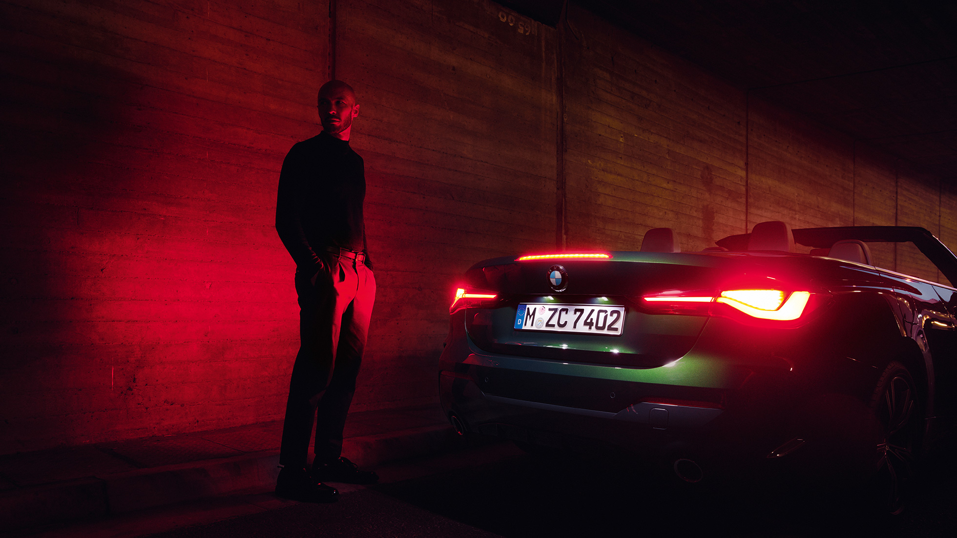 Imagine cu trei sferturi din partea din spate a BMW Seria 4 Cabriolet G23 2020, cu softtop-ul deschis Imagine cu trei sferturi din partea din spate a BMW Seria 4 Cabriolet G23 2020, Verde Sanremo, noaptea, cu softtop-ul deschis