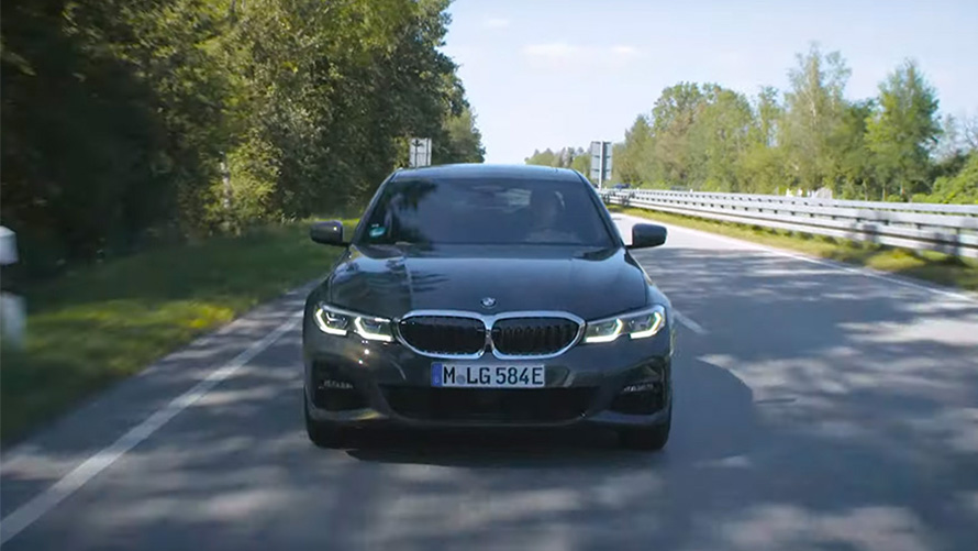 Un BMW plug-in hybrid care se deplasează pe stradă Imagine din partea frontală cu un BMW plug-in hybrid rulând pe stradă