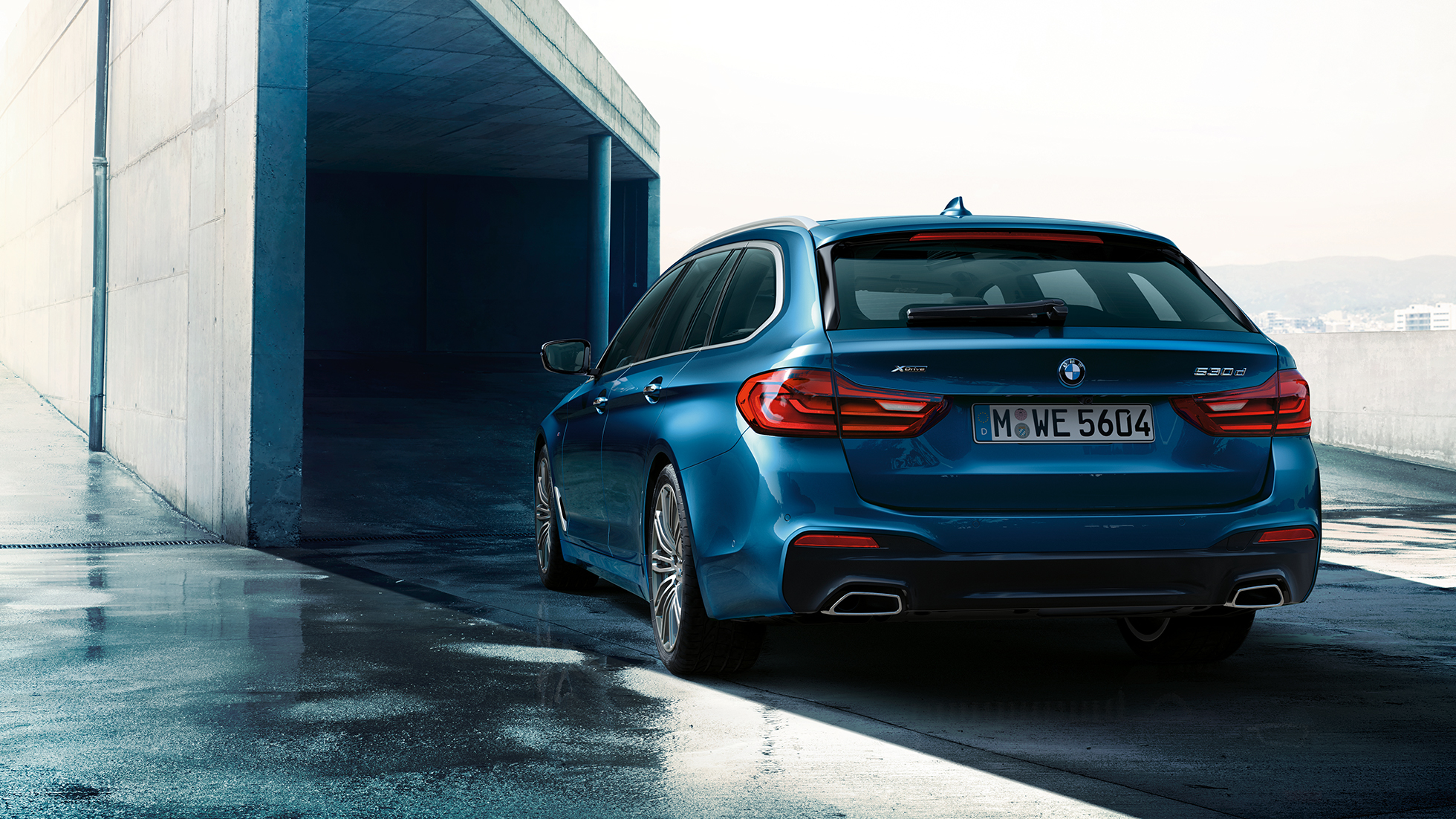 Designul părţii spate a BMW Seria 5 Touring Imagine cu trei sferturi din partea spate a BMW 530d xDrive Touring, G31, în Albastru Mediterranean metalizat