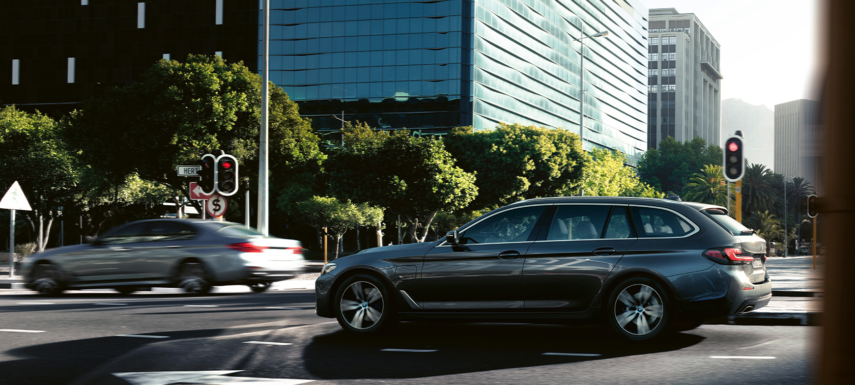 BMW Seria 5 Touring, G31, rulând Imagine cu partea laterală a BMW Seria 5 Touring, G31, Facelift, 2020, în Gri Sophisto, rulând prin oraş