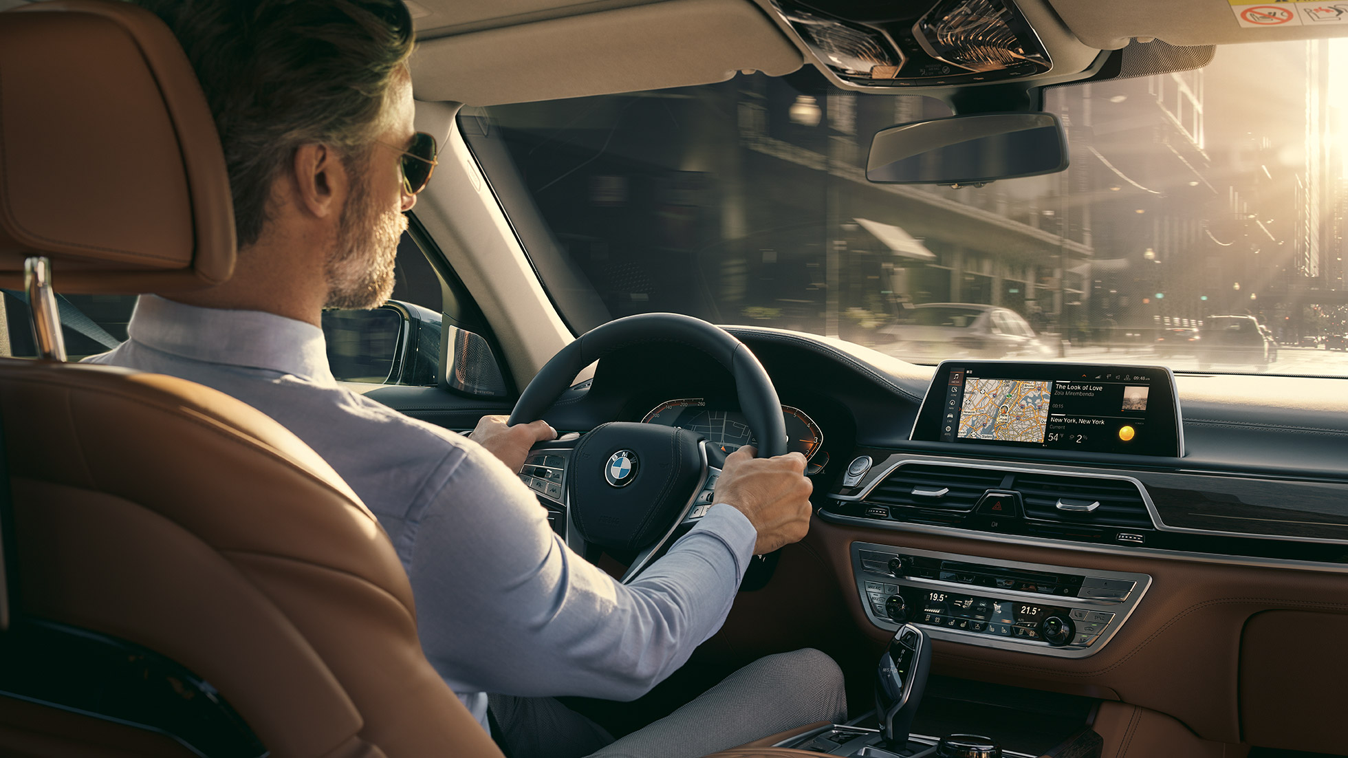 Funcţiile pentru conectivitate ale BMW Seria 7 Sedan BMW Seria 7 Sedan: un bărbat stă într-un automobil BMW şi foloseşte funcţiile pentru conectivitate