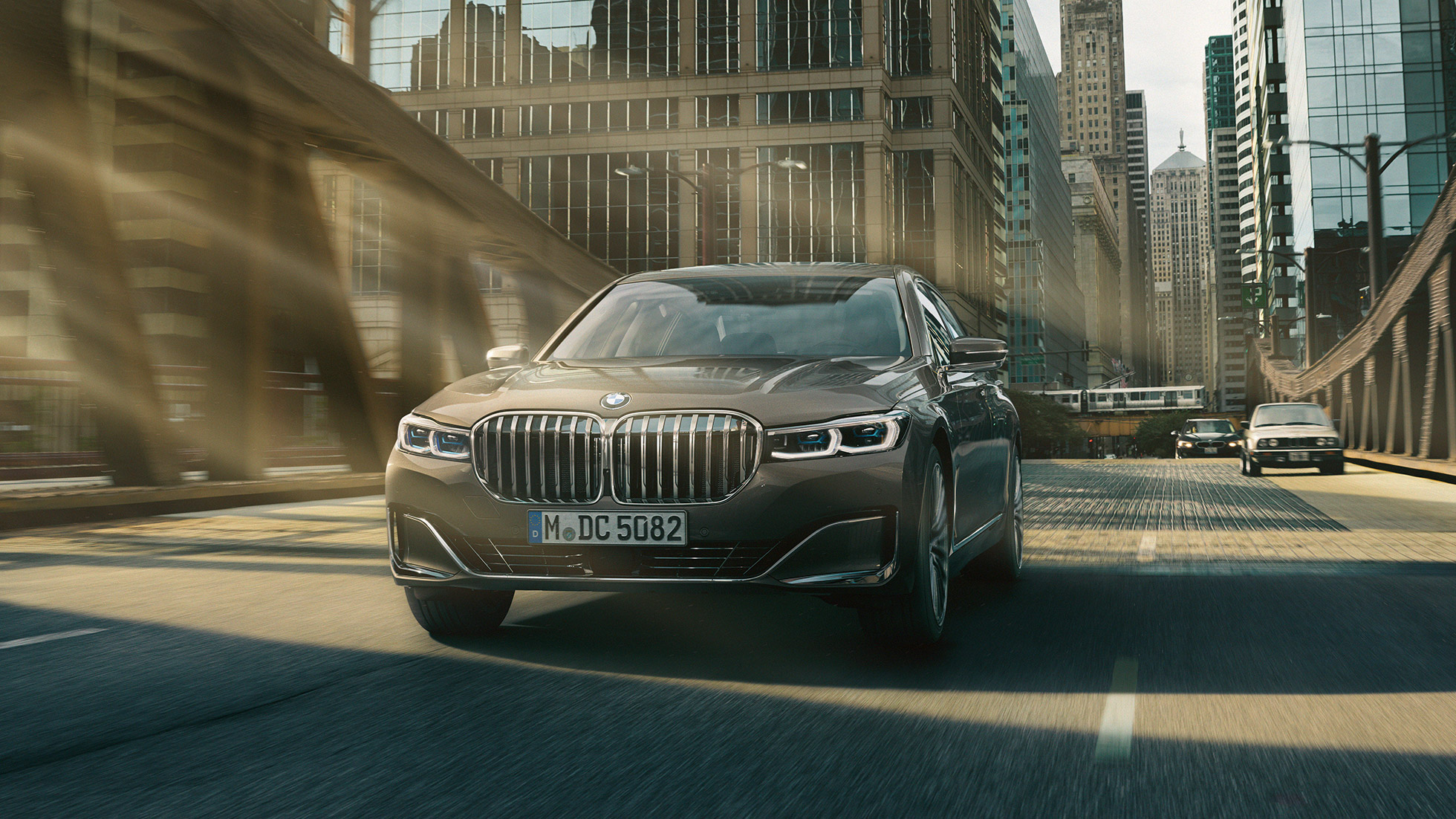 Sistemele de asistare a conducătorului auto ale BMW Seria 7 Sedan Sisteme de asistare a conducătorului auto: BMW Seria 7 Sedan rulând în faţa unui peisaj urban