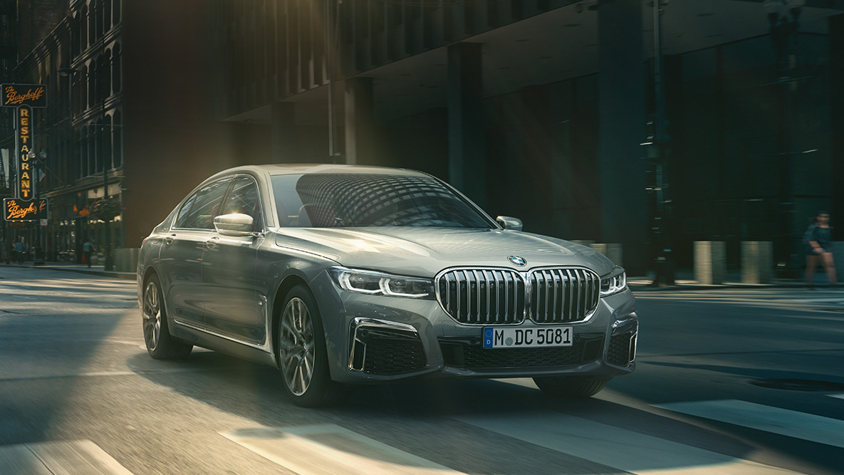 Driving Assistant Professional al BMW Seria 7 Sedan Imagine cu trei sferturi din partea frontală a BMW Seria 7 Sedan cu Driving Assistant Professional, rulând în faţa unui peisaj urban