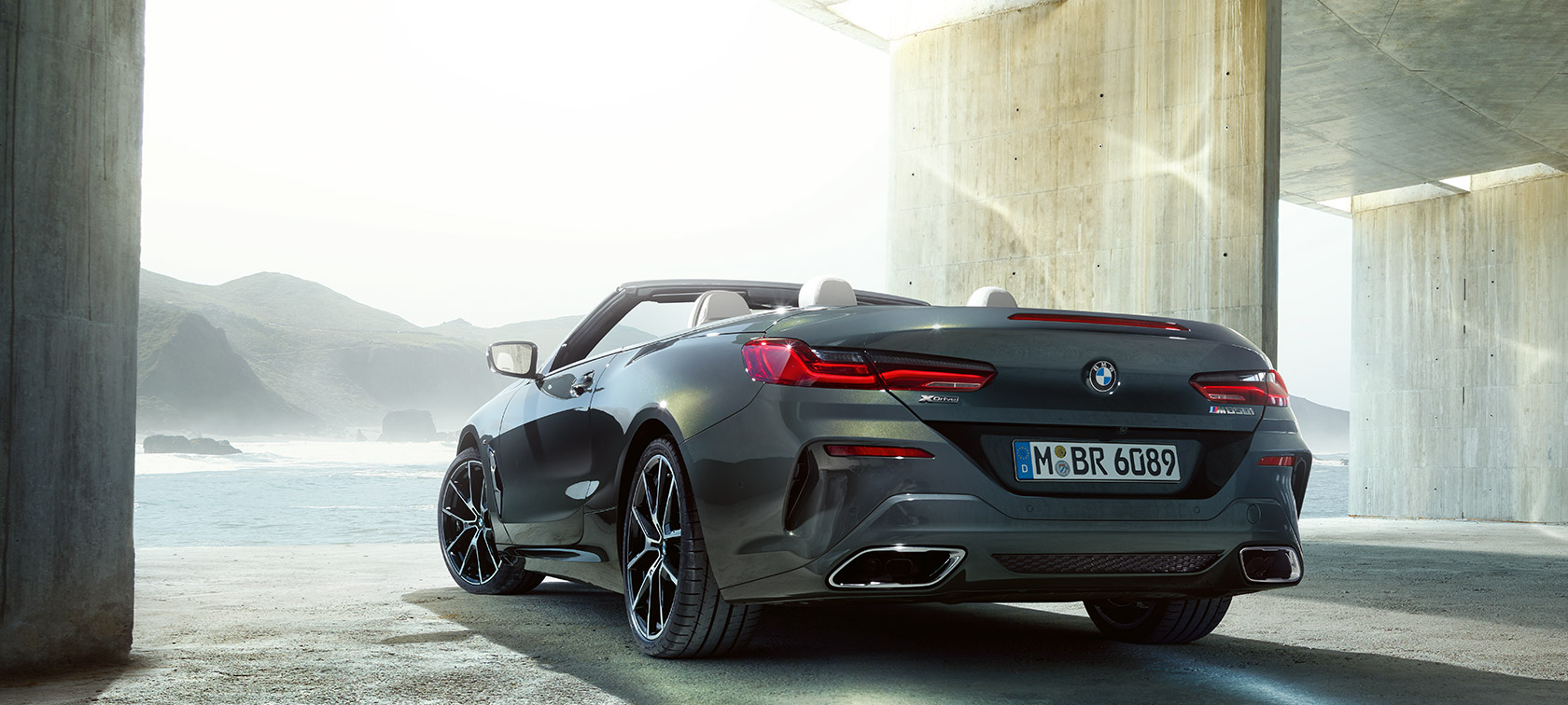 Imagine cu trei sferturi din partea stângă-spate a BMW M850i xDrive în Gri Dravit metalizat. Imagine cu trei sferturi din partea stângă-spate a BMW M850i xDrive în Gri Dravit metalizat.