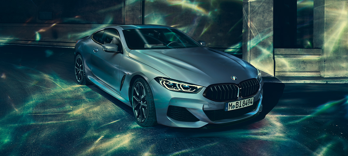 Imagine cu trei sferturi din partea frontală a BMW M850i Coupé „First Edition” Imagine cu trei sferturi din partea frontală a BMW M850i Coupé „First Edition” staţionând într-un peisaj urban