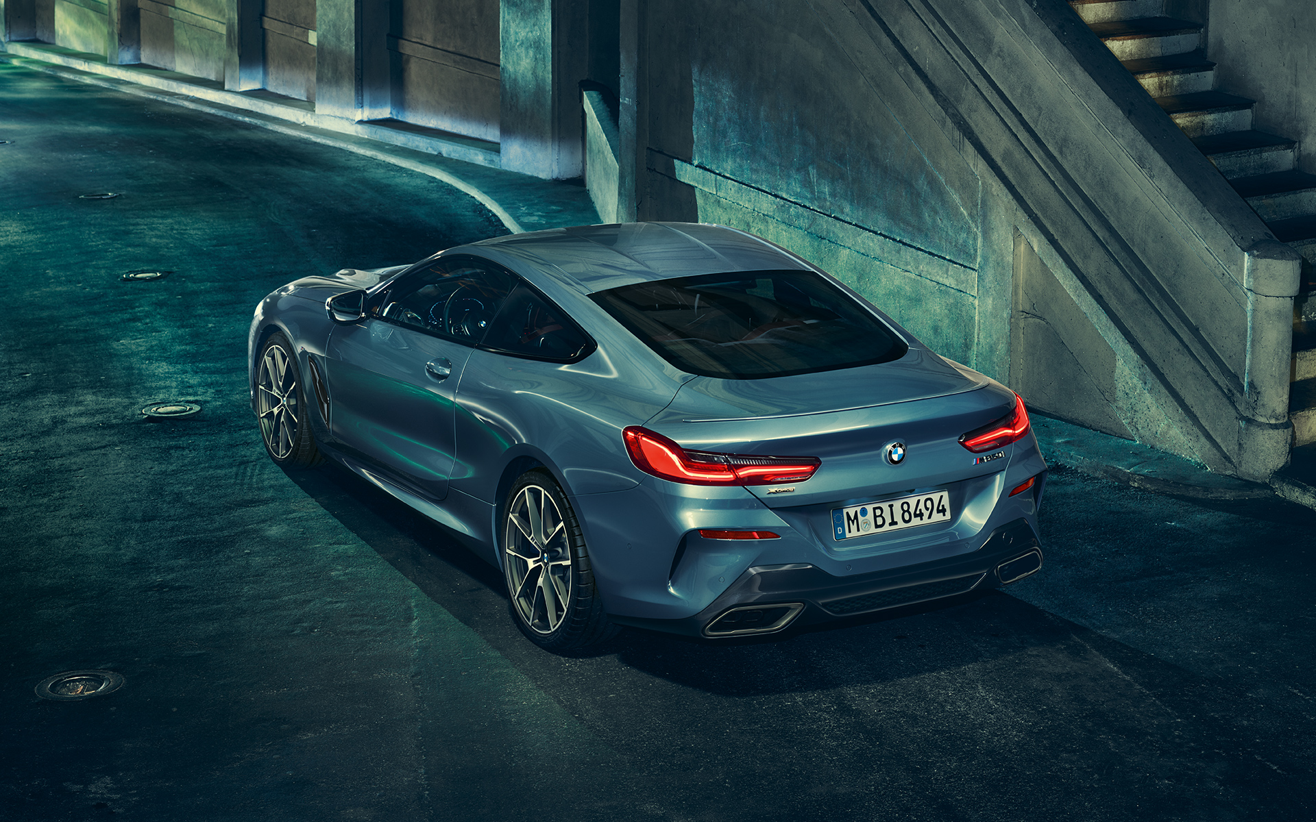 Imagine cu trei sferturi din partea spate a BMW Seria 8 Coupé Imagine cu trei sferturi din partea spate-stânga a BMW Seria 8 Coupé staţionând într-un peisaj urban.