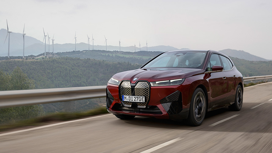 Sustenabilitate BMW iX xDrive50 i20 SUV electric BMW iX xDrive50 i20 2021 SUV electric în timp ce se deplasează pe o şosea de coastă în mod sustenabil