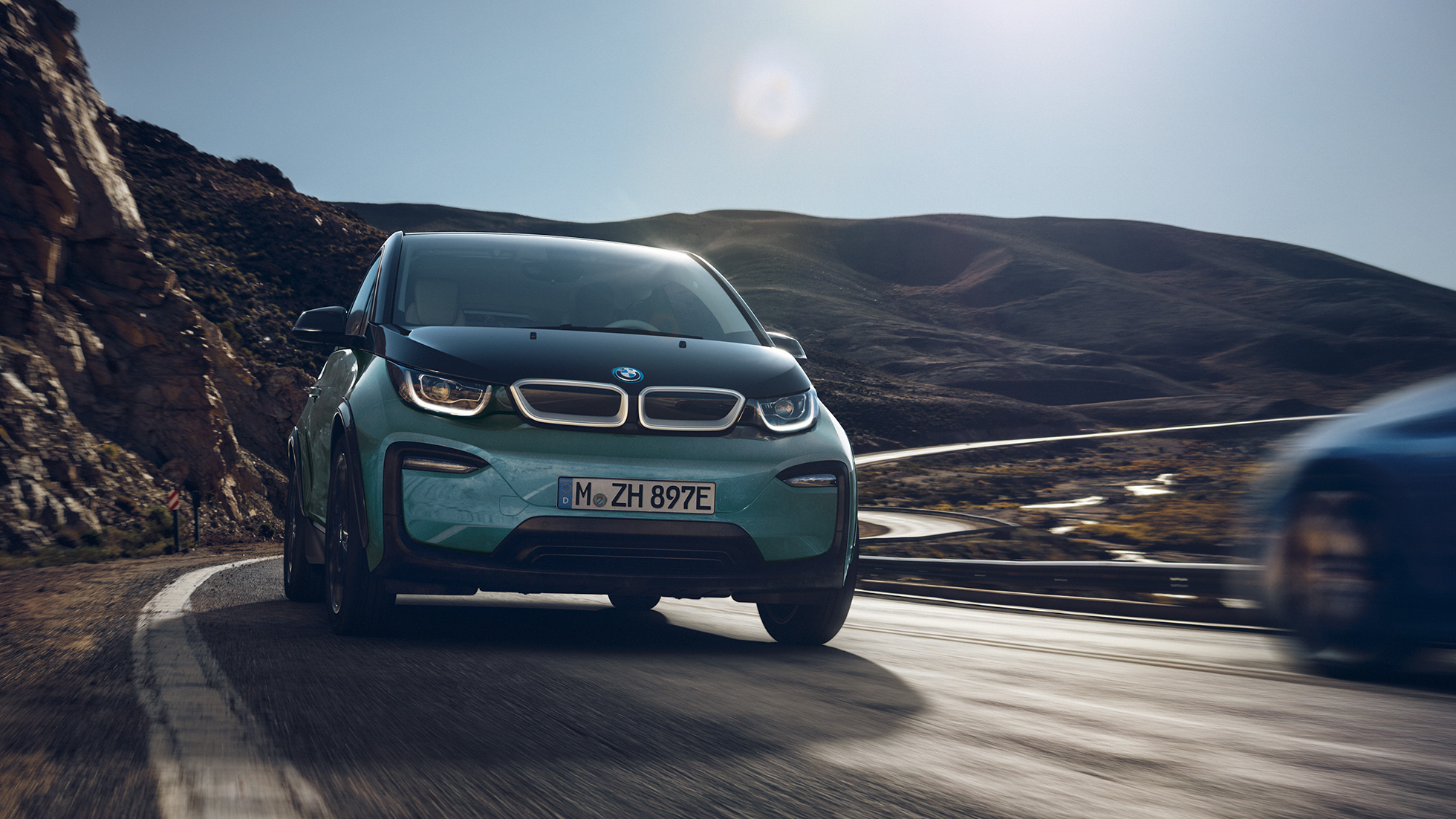 Imagine cu partea laterală a BMW i3, 2018, rulând Imagine cu partea laterală a BMW i3, I01, 2018, în Bej Jucaro cu detalii în Gri Frozen metalizat, rulând într-un spaţiu urban