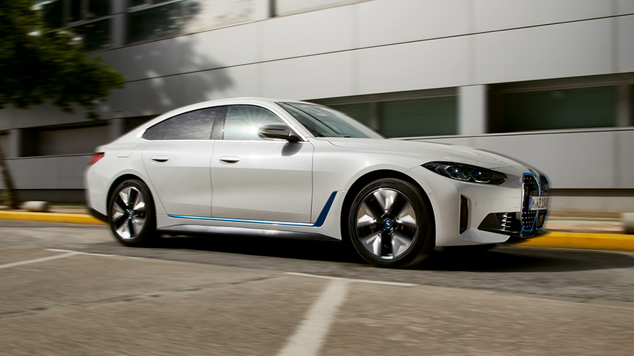 Imagine din partea laterală cu BMW i4 G26 2021 în faţa unei clădiri Imagine din partea laterală cu BMW i4 G26 2021 în faţa unei clădiri