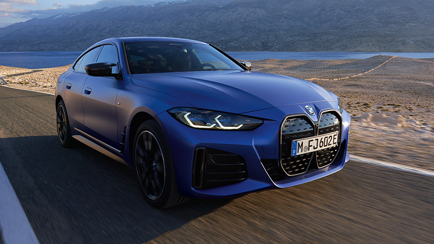 Imagine cu trei sferturi din partea frontală a unui BMW i4 M50 G26 2021 Imagine cu trei sferturi din partea frontală a unui BMW i4 M50 G26 2021 Albastru Portimao M care se deplasează pe şosea