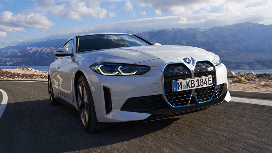 Imagine cu trei sferturi din partea frontală a unui BMW i4 eDrive40 G26 2021 în timp ce se deplasează Imagine cu trei sferturi din partea frontală a unui BMW i4 eDrive40 G26 2021 Alb Mineral în timp ce se deplasează
