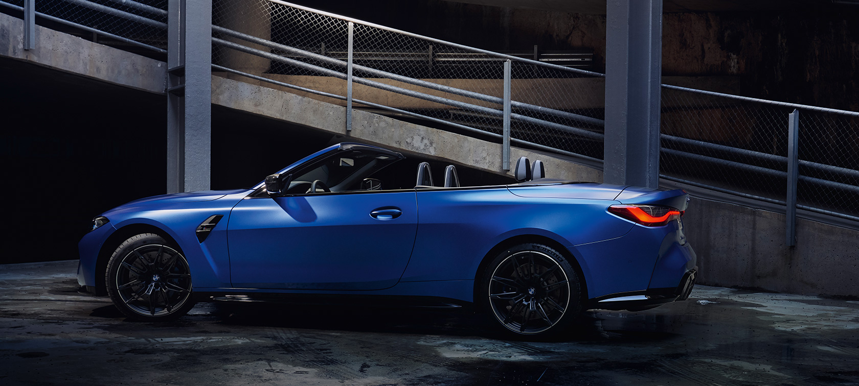 Imagine din partea laterală a BMW M4 Competition Cabriolet G83 2021 cu xDrive M, staţionând Imagine din partea laterală a BMW M4 Competition Cabriolet G83 2021 cu xDrive M, în BMW Individual Albastru Frozen Portimao, staţionând