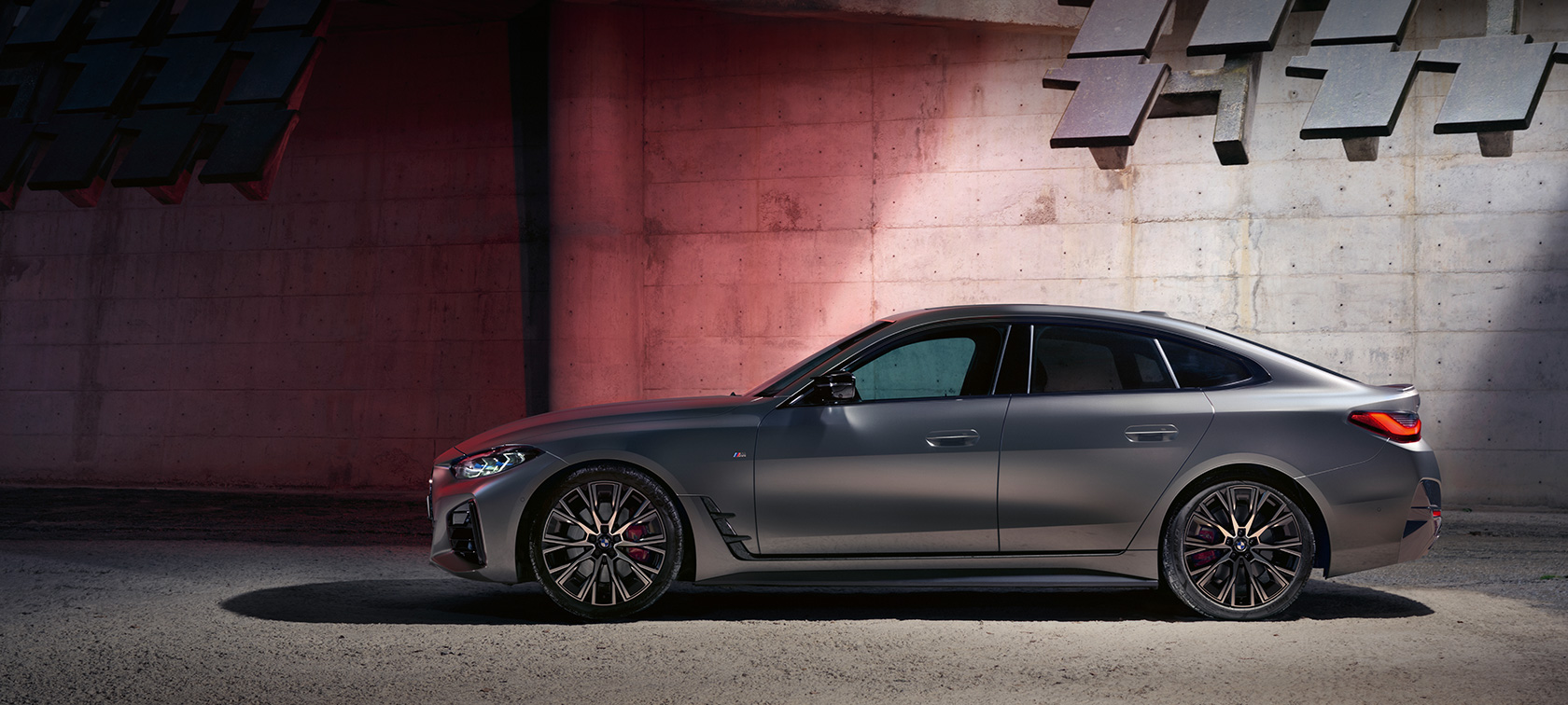 Imagine din partea laterală a BMW M440i xDrive Gran Coupé G26 2021, în faţa unui perete Imagine din partea laterală a BMW M440i xDrive Gran Coupé G26 2021, în BMW Individual Gri Frozen Pure, în faţa unui perete