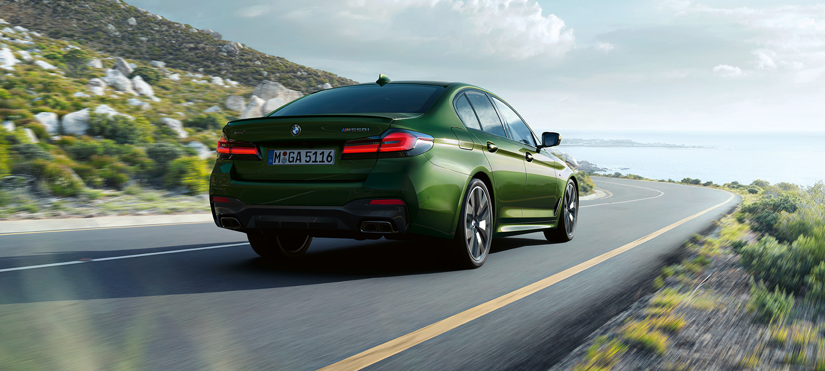Imagine cu trei sferturi din partea spate a BMW M550i xDrive Sedan, G30, LCI, Facelift, 2020, rulând Imagine cu trei sferturi din partea spate a BMW M550i xDrive Sedan, G30, LCI, Facelift, 2020, în Verde Ermes metalizat de la BMW Individual, rulând