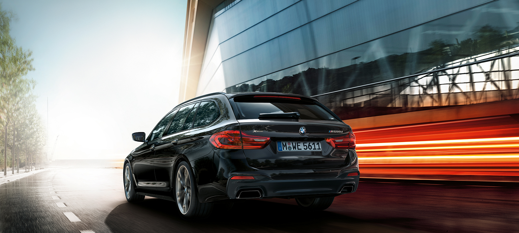 Imagine cu trei sferturi din partea spate a BMW M550d xDrive Touring Imagine cu trei sferturi din partea spate a BMW M550d xDrive Touring, G31, în Negru Azurite metalizat