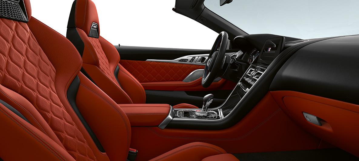 Piele Merino integrală în Portocaliu Sakhir, cu granulaţie fină şi ornamente interioare în Negru Piano de la BMW Individual. Interiorul BMW M8 Cabriolet din piele Merino integrală în Portocaliu Sakhir, cu granulaţie fină şi ornamente interioare în Negru Piano de la BMW Individual.